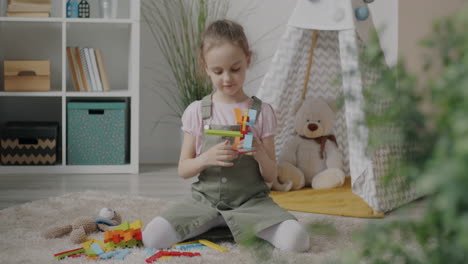 little girl playing with colorful building blocks