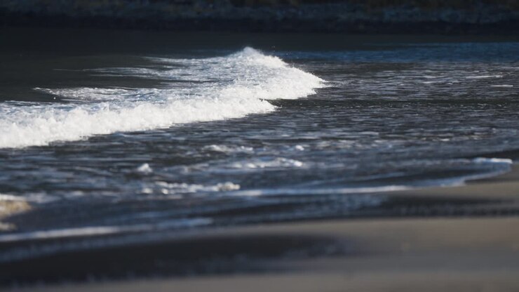 Gentle waves roll on the shallows of the sandy beach in Ersfjord