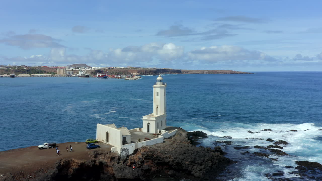 Aerial orbiting shot over Dona Maria pia Lighthouse with Praia city in Background, Santiago Island