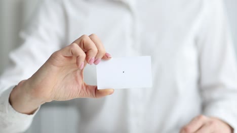 businesswoman holds out white business card for dating