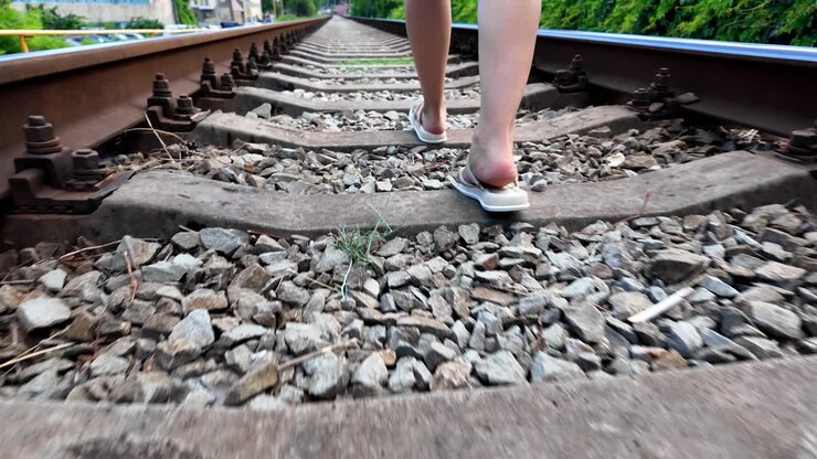Una persona cammina lungo i binari della ferrovia in Crimea in una giornata di sole
