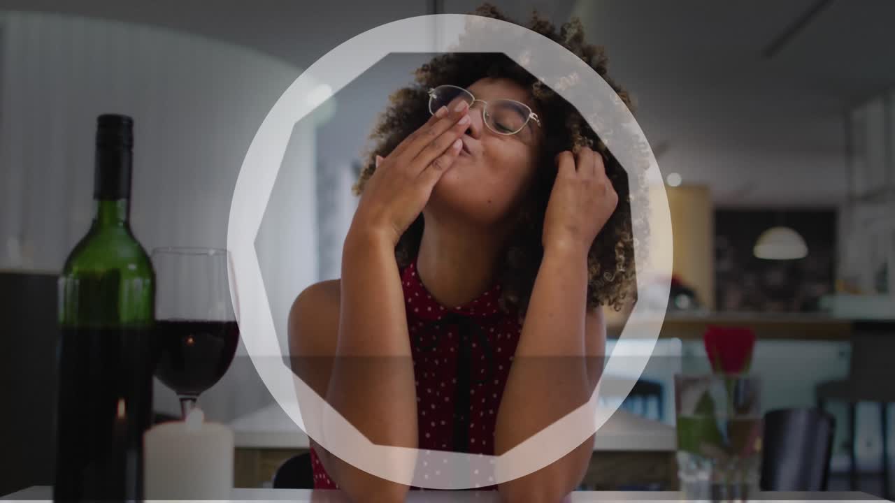 animación del círculo sobre una feliz mujer biracial con vino haciendo una videollamada