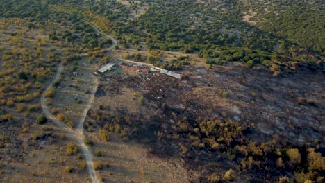 Αerial-descending-over-livestock-enclosure-that-was-destroyed-by-wildfires-in-northern-Greece,-August-2023