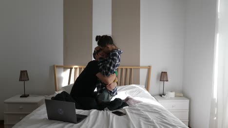 pareja abrazándose y besándose en la cama