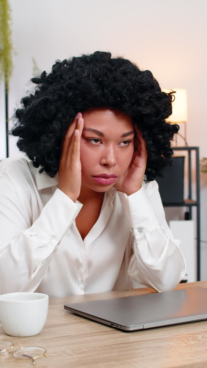 Donna d'affari afroamericana stanca chiude il laptop, agita la mano improvvisamente frustrata e annoiata dal lavoro monotono.
