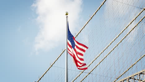 american flag flying by brooklyn bridge in new york