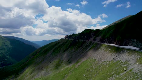 Aerial-View-Of-Transfagarasan-Mountain-Road-Crossing-the-Carpathian-Mountains-in-Romania,-Aerial-View-Of-A-Beautiful-Mountain-Range-With-High-Peaks,-Thick-Fluffy-Clouds