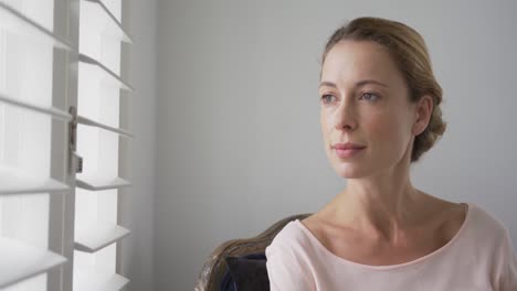mujer mirando por la ventana en una casa cómoda 4k