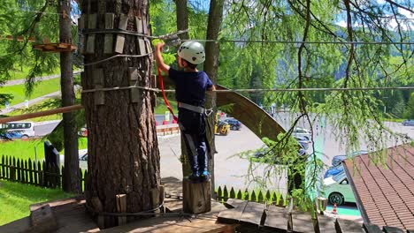 children crossing a forest via ferrata in slow motion in alta badia, dolomites, italy during a family outdoor adventure practicing clipping in