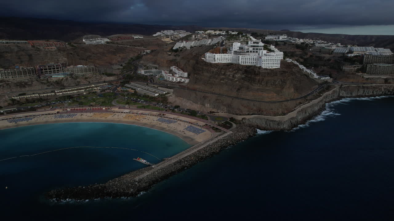 fantástica toma aérea en órbita de la playa de amadores y los grandes hoteles de la zona, durante la puesta de sol en la isla de gran canaria
