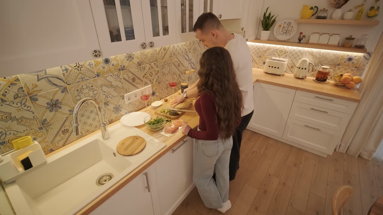 una pareja enamorada haciendo un sándwich en la cocina de la sala de estar