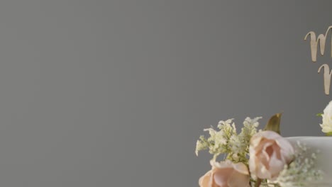 Close-Up-Of-Wedding-Cake-Against-Grey-Studio-Background-At-Wedding-Reception