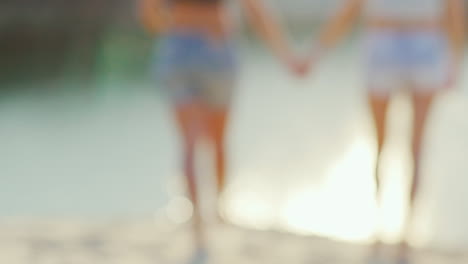 dos mujeres tiernamente toman de la mano pareja romántica