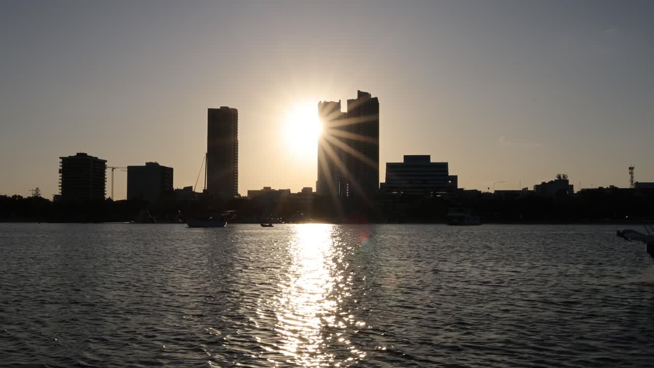 선박이 해가 지면 도시 스카이라인을 지나간다