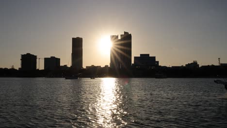 un barco pasa por el horizonte de la ciudad al atardecer