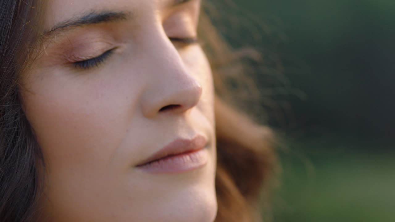 retrato en primer plano de una mujer hermosa disfrutando de una tranquila puesta de sol explorando la espiritualidad mirando hacia arriba orando contemplando el viaje con el viento soplando el cabello