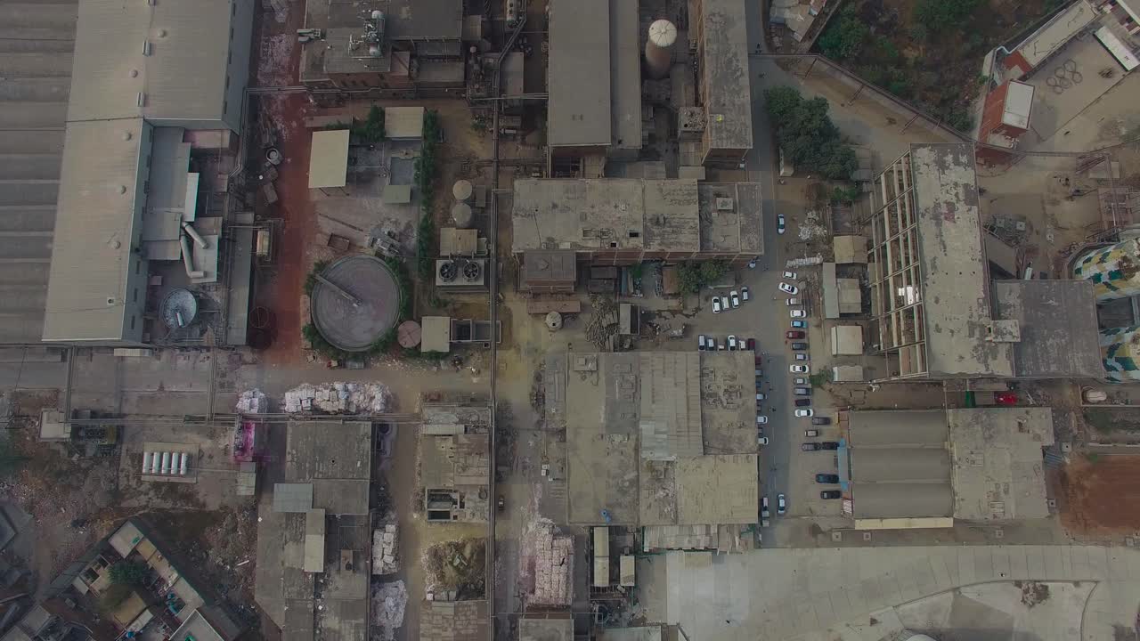 Top shot of a refinery and a factory, Bombay, India, showing roofs of the factory, cars parked at outside of the factory