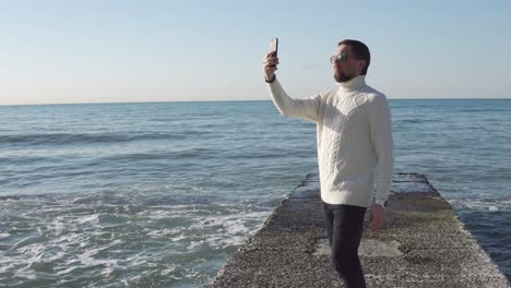 man taking selfie on a beach pier