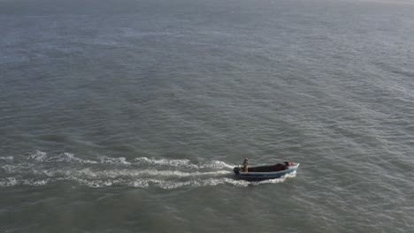 pequeño bote de langosta abierto cruza el marco de izquierda a derecha en aguas abiertas