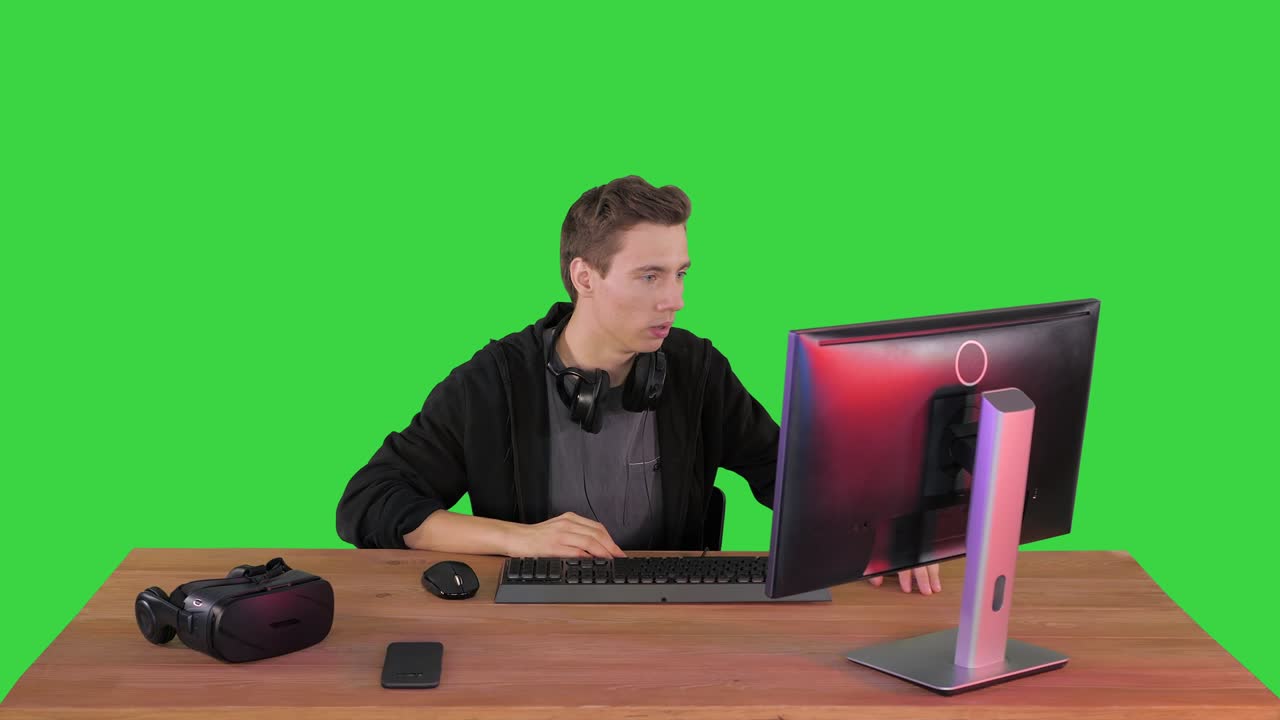 초록색 화면, 크로마 키에서 pc 컴퓨터에서 비디오 게임을 보는 긴장한 남자