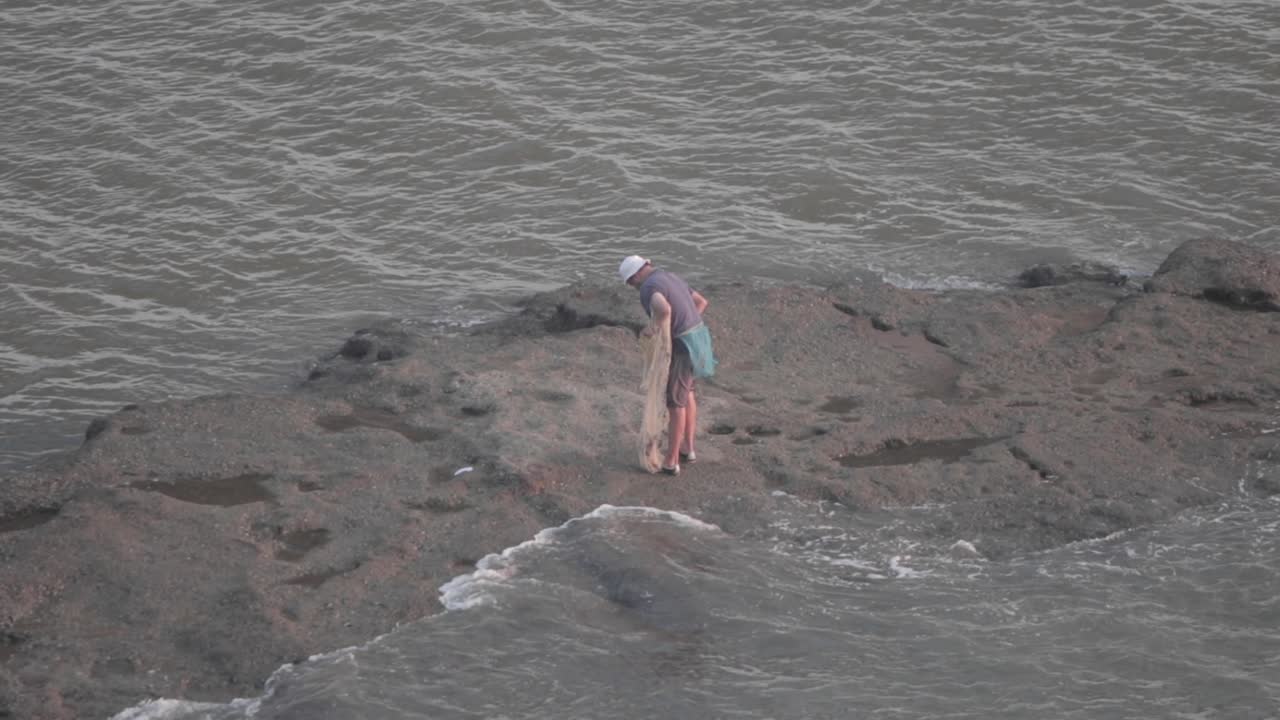 pescador indio local recogiendo su red de pesca