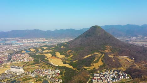aerial: landscape view during the day of mountain and cityscape in chizhou city, anhui province, china, establishing drone shot