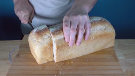 rustic loaf of bread being sliced with bread knife