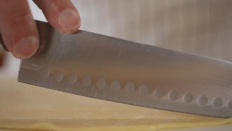 primo piano del taglio dei lati di un quadrato di pasta pastosa durante la preparazione di crostate pop gourmet