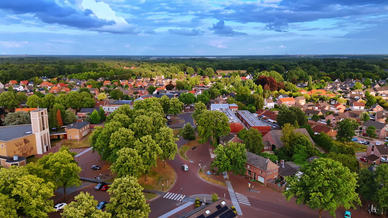Colorful Dutch suburb among trees. Aerial capture of a bright Dutch suburb framed by lush green trees
