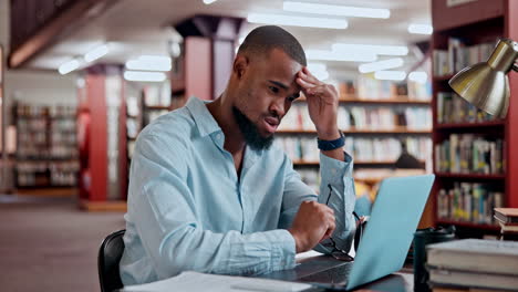 man concentrating on laptop in a library