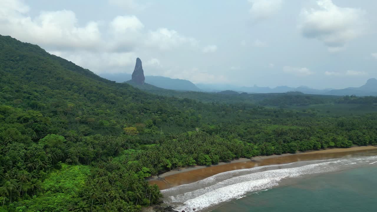 Flying over Praia Grande with Pico Cão Grande mountain background, at a sunny day in south of Sao Tome,Africa.