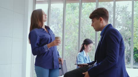 mujer de negocios feliz y hombre de negocios teniendo una conversación en una oficina moderna.