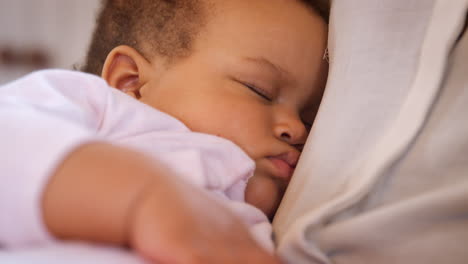 primer plano de la nueva madre acurrucando a la niña durmiendo en la guardería en casa