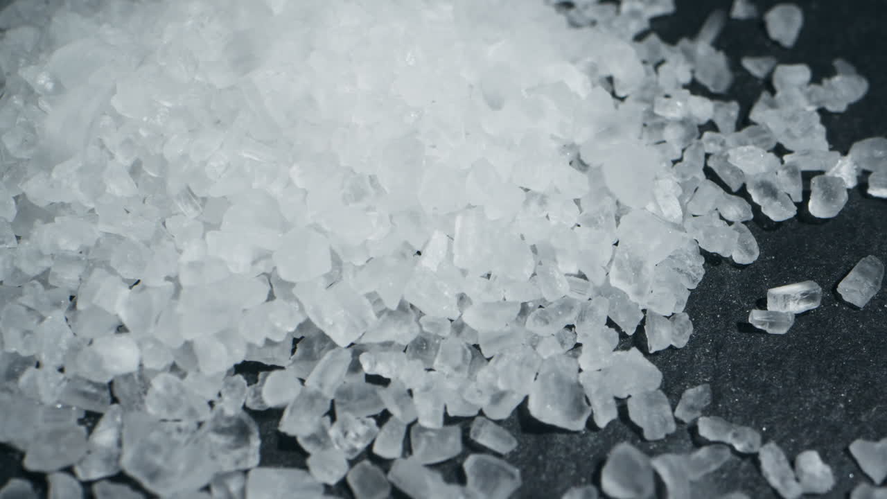 White salt close-up macro. Spice for food. Sea salt for bath. Man hand srewing salt on table . High quality 4k footage