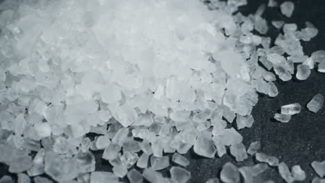 white salt close-up macro. spice for food. sea salt for bath. man hand srewing salt on table . high quality 4k footage