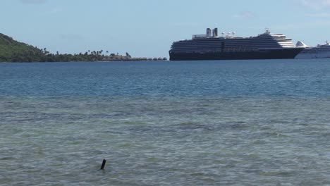 cruise ship in the bay of bora bora, french polynesia.
