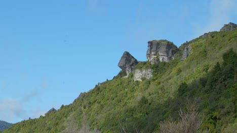 Explore-the-intriguing-landscape-as-we-unveil-a-striking-rock-formation-nestled-amidst-the-picturesque-hillside,-showcasing-nature's-artistry-and-geological-wonder