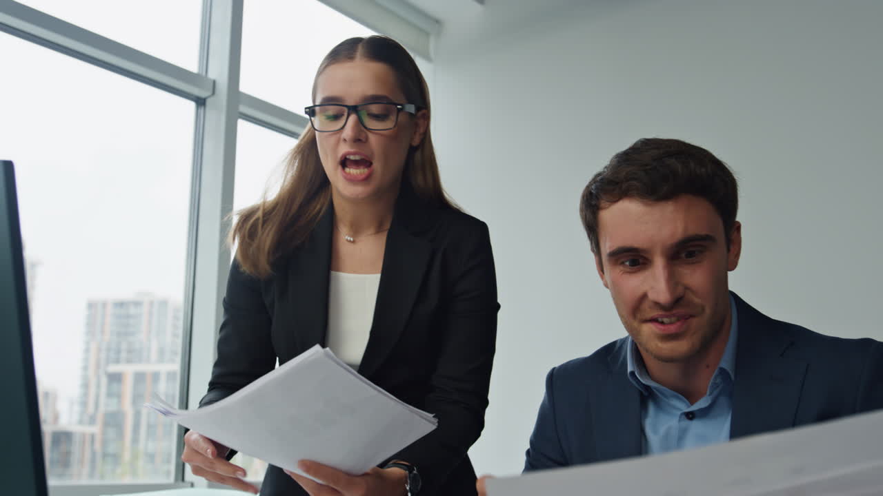 equipo de oficina sonriente trabajando juntos con papeles. dos colegas discuten el proyecto