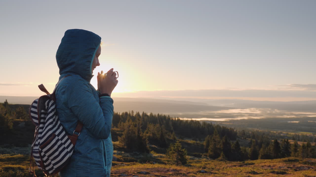 el viajero bebe té caliente en la cima de la montaña admirando el amanecer en el horizonte naturaleza de