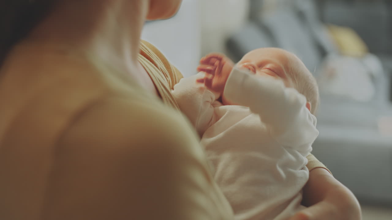 madre sosteniendo a un bebé dormido