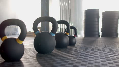 kettlebells lined up on gym floor, ready for fitness training session, copy space