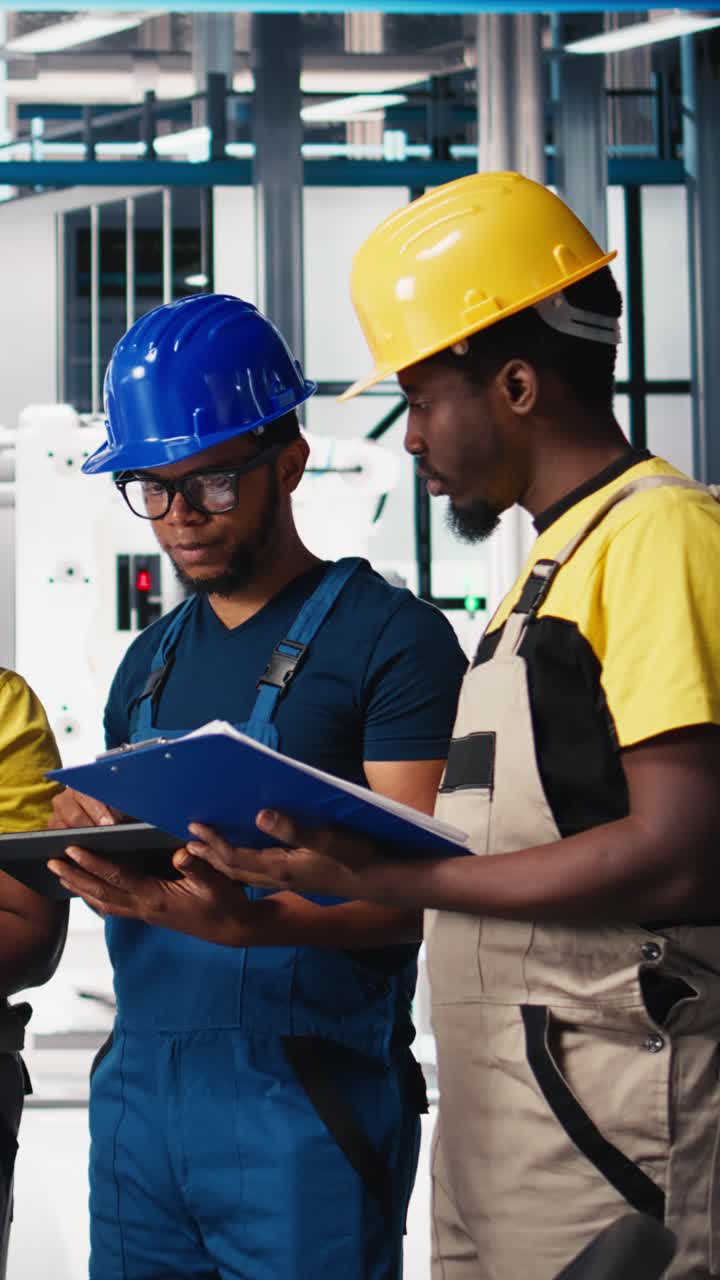 Vertical Video Group of black employees at the solar panels factory reviewing data