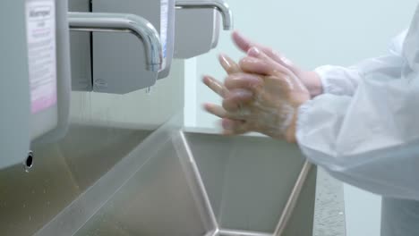 employee washing hands in a clean room setting