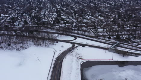 Una-Vista-Aérea-Desde-Un-Dron,-Sobre-Una-Carretera-Despejada-Con-Un-Lago-Congelado-A-Ambos-Lados