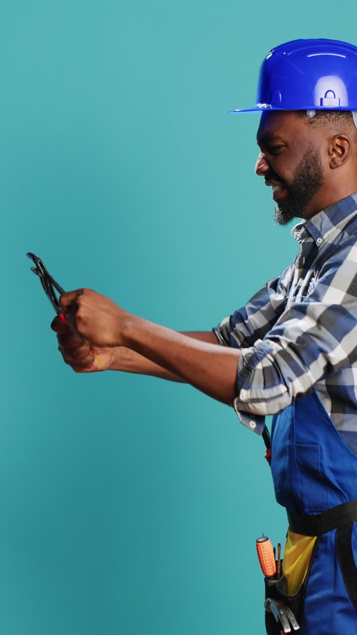 Vertical video: Construction worker clamping something with wrench