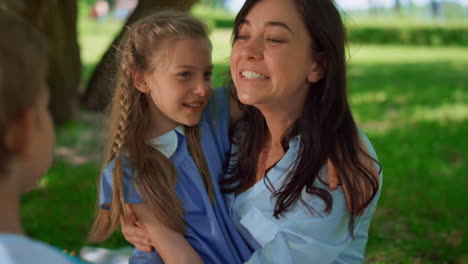 la madre sonriente abraza a los niños en un picnic de cerca. concepto de maternidad feliz.