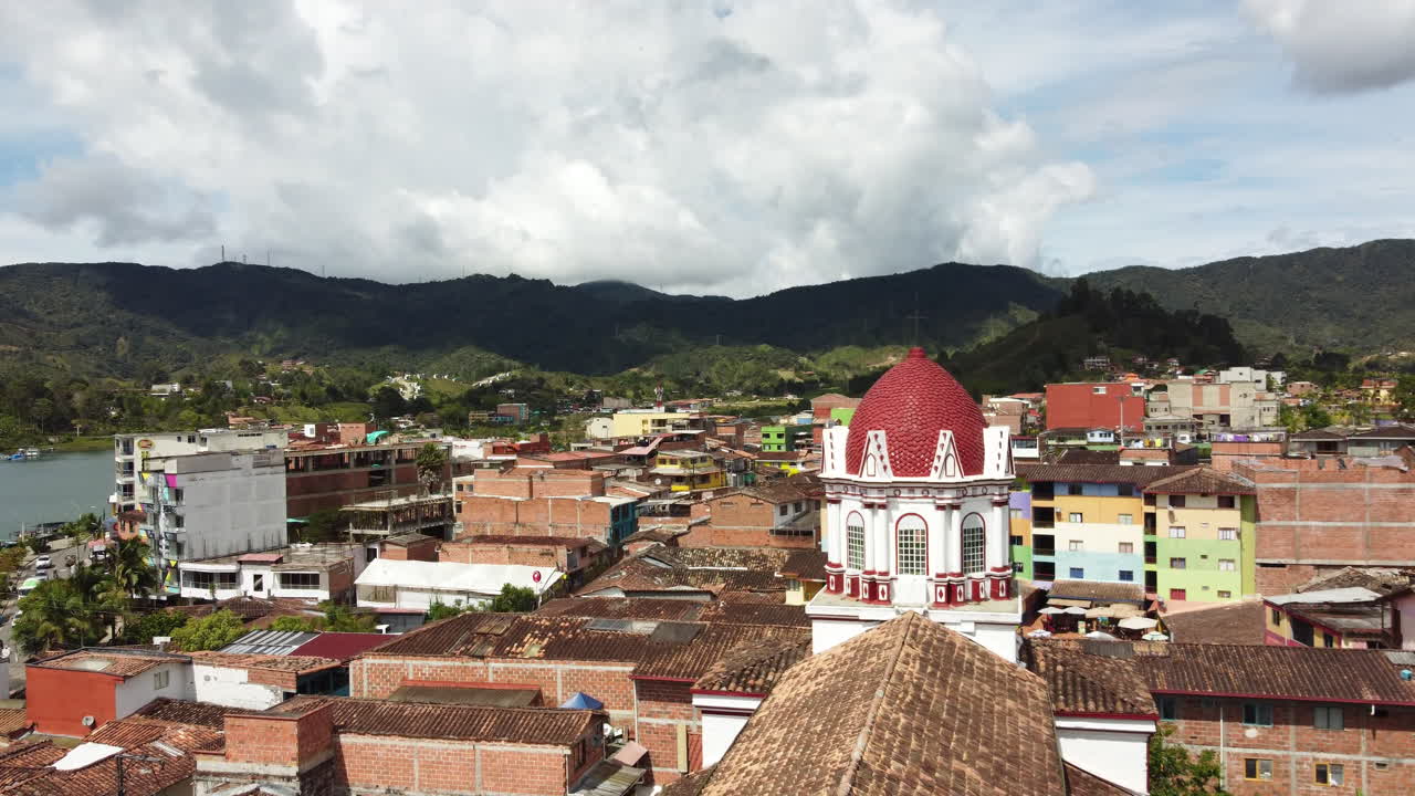 Drone footage of the roof tops down town in Guatapé including the roof top of the Catholic church, Antioquia, Colombia.