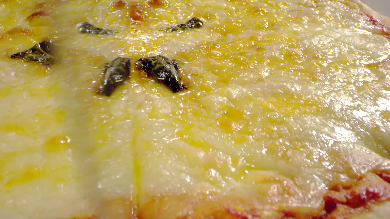 toma macro cortando pizza con queso y salsa de tomate