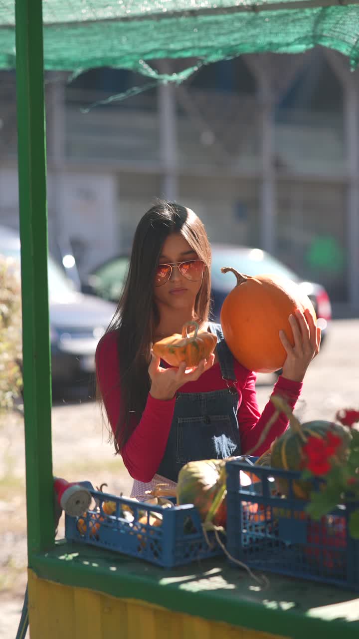 mujer comprando calabazas en un mercado de otoño