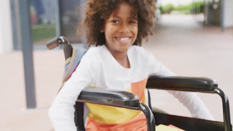 Videoporträt-Eines-Lächelnden-Afroamerikanischen-Schuljungen-Im-Rollstuhl-Im-Schulkorridor
